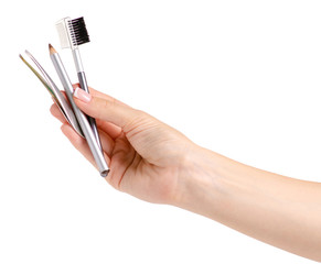 Brush for eyebrow pencil tweezers in hands on white background isolation