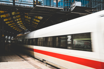 Naklejka premium odjazd pociągu na stacji kolejowej - rozmycie ruchu pociągu opuszczającego platformę
