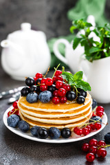 Pancakes with fresh berries. Pancakes with raspberry, blueberry, redcurrant, black currant and honey