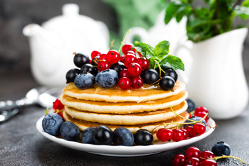 Pancakes with fresh berries. Pancakes with raspberry, blueberry, redcurrant, black currant and honey