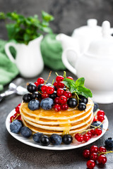 Pancakes with fresh berries. Pancakes with raspberry, blueberry, redcurrant, black currant and honey