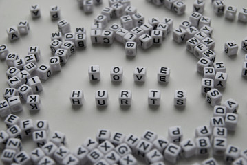 love hurts word written on cubes on white background. Creative text for your business. Chaotic letters design