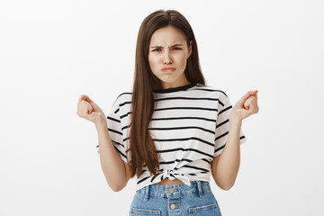 Offended girl looking cute when angry. Portrait of outraged tender feminine woman, raising clenched...