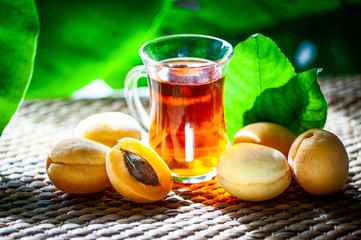 Fruits tea made from Аpricots , organic tea , fresh apricots  fruits whole and half on a natural tropical background.