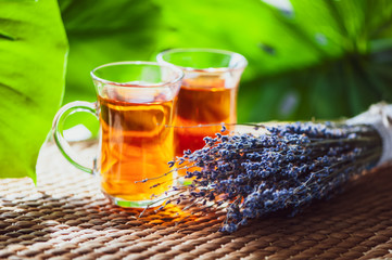 Two cups of tea and a bouquet of lavender on a background of a beautiful, natural  green background