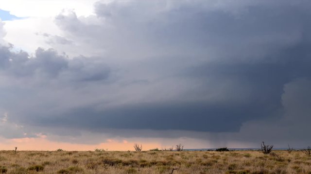 Large, powerful tornadic supercell storm moving over the Great Plains during sunset, setting the stage for the formation of tornados across Tornado Alley. 
