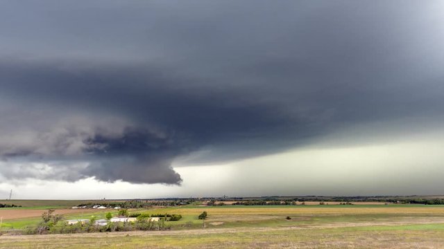 Large, powerful tornadic supercell storm moving over a small town in Oklahoma sets the stage for the formation of tornados across Tornado Alley. 

