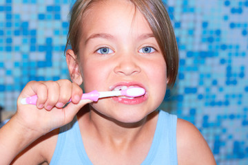  A little girl is brushing her teeth.