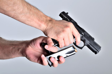 Detail of man's hand reloading pistol after shooting