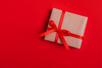 Present box with red bow on colorful background
