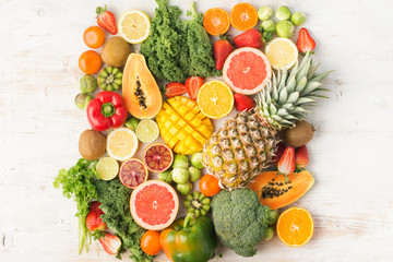 Fruits and vegetables rich in vitamin C background pattern, oranges mango grapefruit kiwi kale pepper pineapple lemon sprouts papaya broccoli, on white table, top view, copy space selective focus