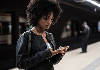Black woman inside the underground station waiting for the train