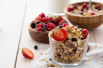Healthy breakfast. Fresh granola, muesli in a glass jar. Copy Space. Organic oat,almond,fresh berry, milk, sunflower seeds.