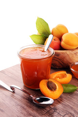 Apricot jam in glass bowl with fruit around