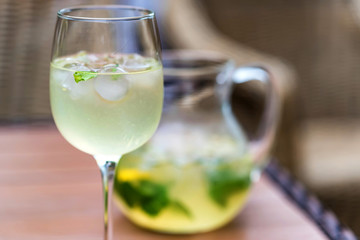 Refreshing Mojito cocktail in glass and jug close