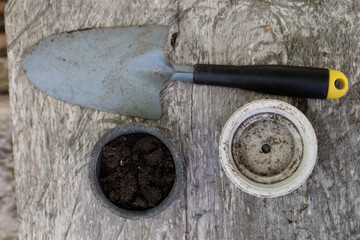Black soil and flower pots intended for flower growing. Transplanting plants in a home garden.