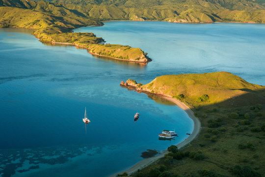 View from top of Gili Lawa in the morning with clear blue sea and tourist boats, Komodo Island (Komodo National Park), Labuan Bajo, Flores, Indonesia