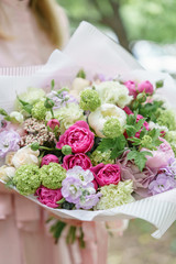 Young girl holding a beautiful summer bouquet. flower arrangement with peonies. The concept of a flower shop. Content for the catalog