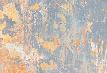 closeup of old wall with yellow and blue paint peeling off