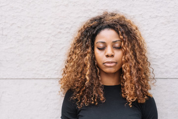 Calm young African woman with her eyes closed