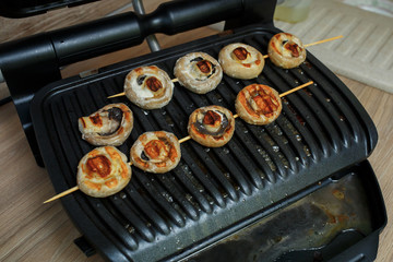 Mushrooms champignons are cooked on the grill, fried mushrooms