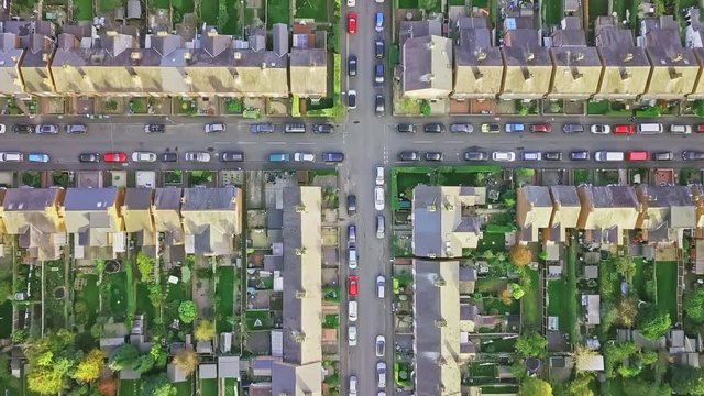 Aerial view of traditional British neighbourhood taken at sunset. Camera pans across the roofs of rows of old terraced houses