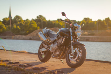 Obraz premium Motocykl na wodzie o zachodzie słońca