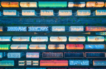 Aerial view of cargo trains. Railway wagons with goods on railroad. Top view of colorful freight...