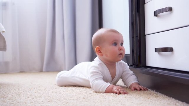 Baby crawling on the floor towards camera