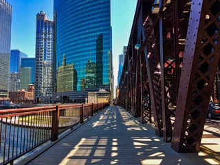  Chicago's elevated train tracks cast shadows on Lake Street and sidewalk along the river in downtown Loop. © shellybychowskishots