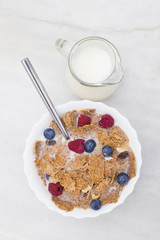 cup cereal with fruit and milk jug, top view