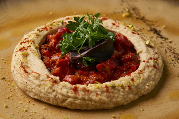 Vegetarian Hummus with harissa sauce and pistachios, close-up, top view