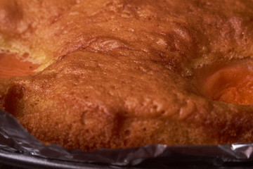 Tart with apricots on wooden table background close up