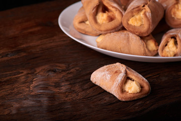 Cookies with Cottage cheese baked in oven, on wooden table and black background. Close up, selective focus. Concept of homemade food