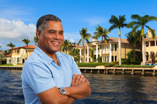 Handsome Hispanic man outdoors by waterfront homes
