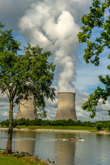 Fototapeta na wymiar Fishing boat floats by the cooling towers of a Nuclear Reactor in Tennessee
