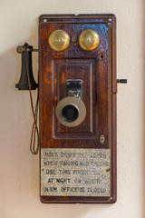 Vintage Wall-Mounted Wooden Telephone With Brass Bells and Handheld Microphone