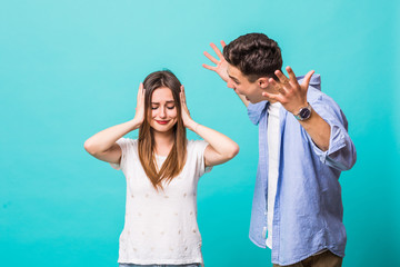Portrait of young angry caucasian loving couple friends isolated over mint blue background quarrel. - obrazy, fototapety, plakaty