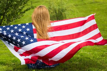 Girl playinfg with the American Flag in windy day