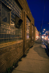 Dark, gritty and wet industrial city sidewalk at night after rain