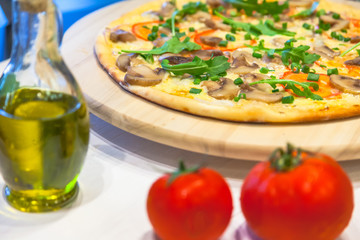 appetizing vegetarian pizza with olive oil on a white table