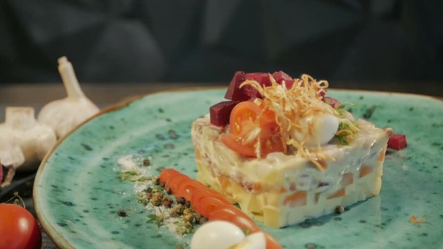 Russian traditional cuisine. Shub salad with herring. Dolly shot. On a black wooden background. Copy space.