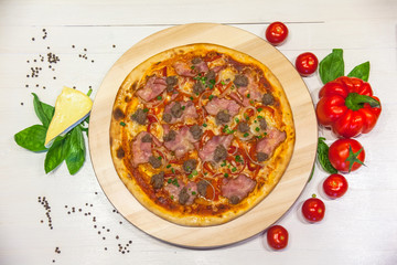 appetizing pizza with bacon, bell pepper and basil on a white table, flat lay
