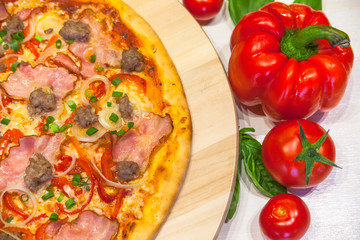 appetizing pizza with bacon, bell pepper and basil on a white table, flat lay