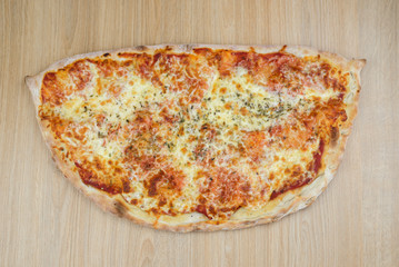 Pizza calzone time on light wooden table background
