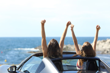 Joyful tourists watching the sea in a convertible car