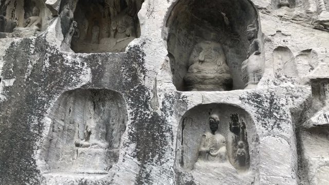 Walking and looking the Buddha Statues in close-up, Longmen Grottoes park, China