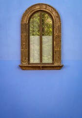 Isolated antique window on exterior Blue stucco wall 