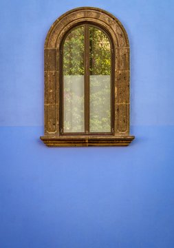 Isolated antique window on exterior Blue stucco wall 