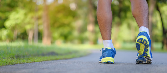 young fitness man legs running in the park outdoor, male runner walking on the road outside, asian...